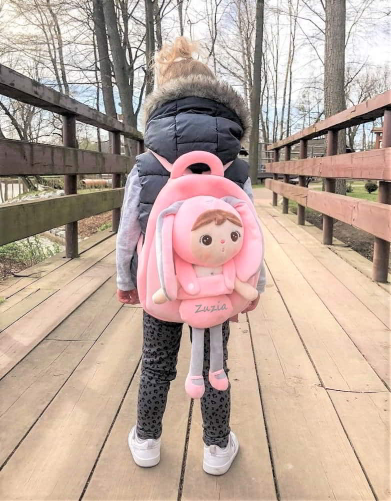 Dziewczynka z różowym plecakiem i lalką Metoo z imieniem