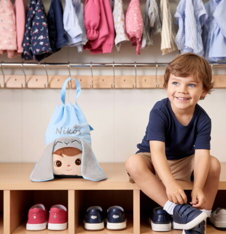 Mały chłopiec z workiem na buty z imieniem z uchwytem z głową królika