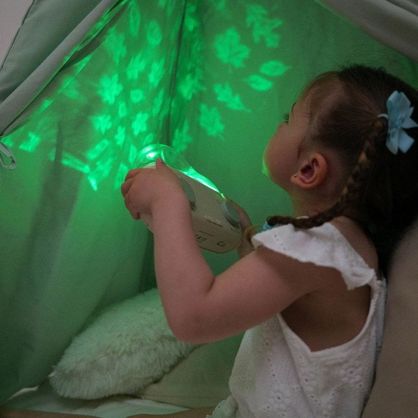 Dziewczynka z projektorem wyświetlającym las